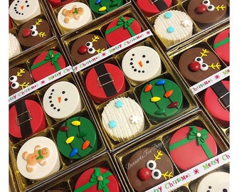 May include: Assortment of Christmas-themed chocolate-covered Oreos in individual boxes. The boxes are decorated with red, green, and white ribbons and feature various designs, including a snowman, a reindeer, a gingerbread man, and a present. The text "Merry Christmas" is printed on the ribbon.