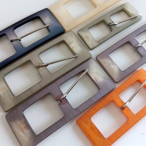 the photo shows pearly plastic buckles rectangle shaped, in the 5 available colors