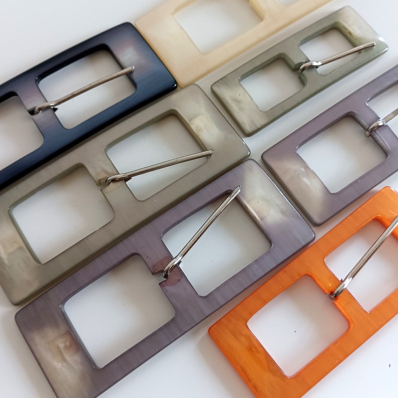 the photo shows pearly plastic buckles rectangle shaped, in the 5 available colors