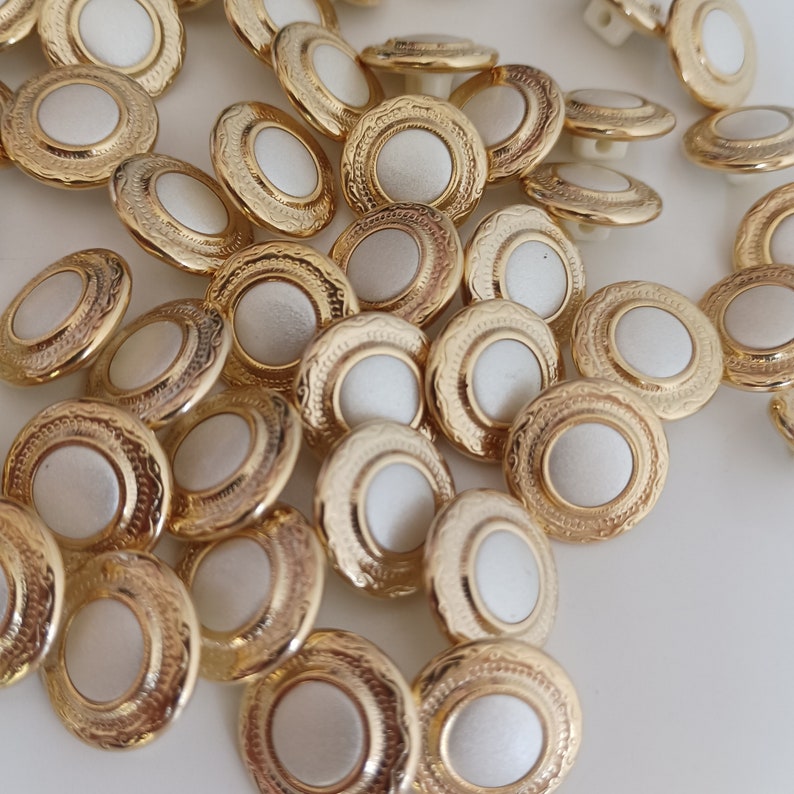 the photo shows gold tone metal and pearly white plastic buttons