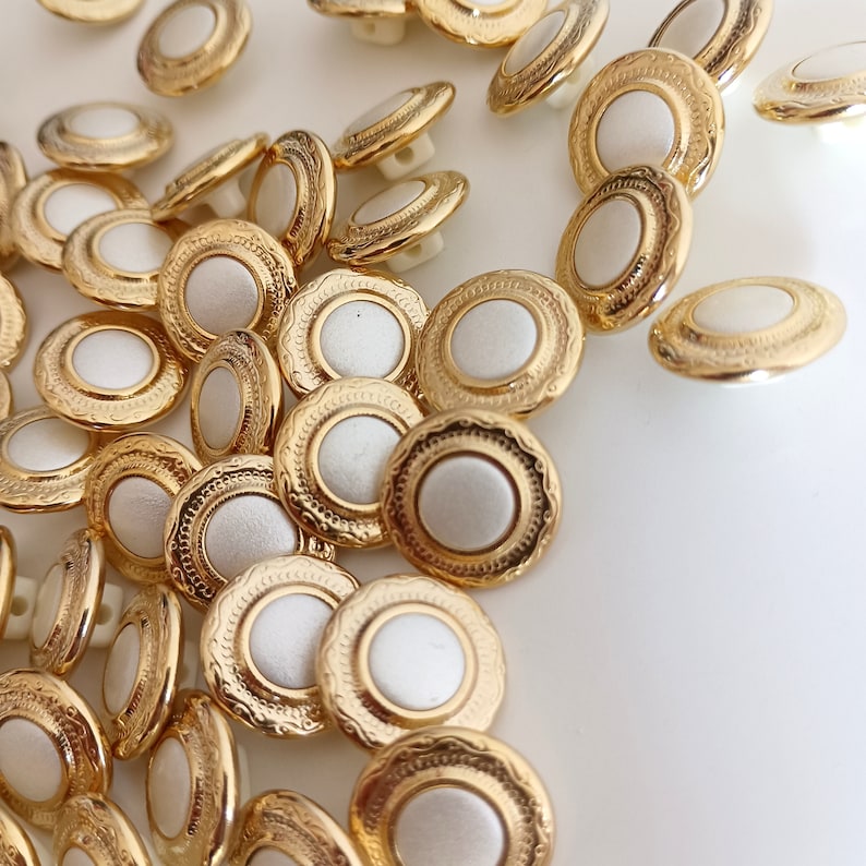 the photo shows gold tone metal and pearly white plastic buttons