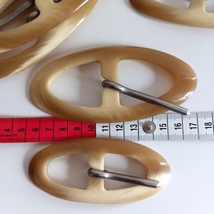 the buckles are photographed next to a tape measure
buckle length: 12cm - 9,5cm