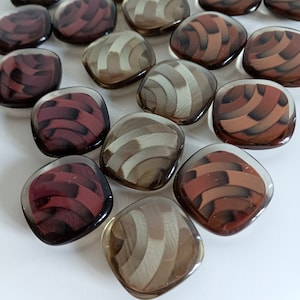 the photo shows clear plastic buttons square shaped in the three available colors: beige, burgundy, brown