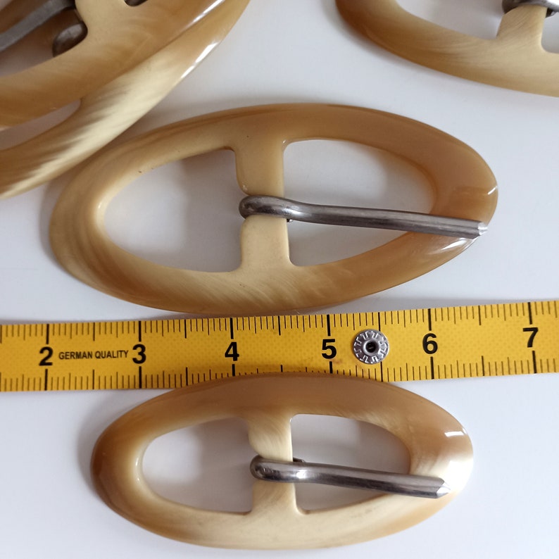 the buckles are photographed next to a tape measure
buckles length: 4.7in - 3.74in