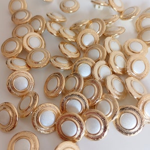 the photo shows gold tone metal and pearly white plastic buttons