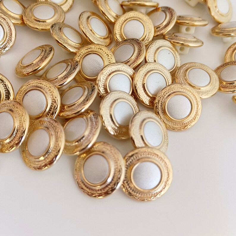 the photo shows gold tone metal and pearly white plastic buttons