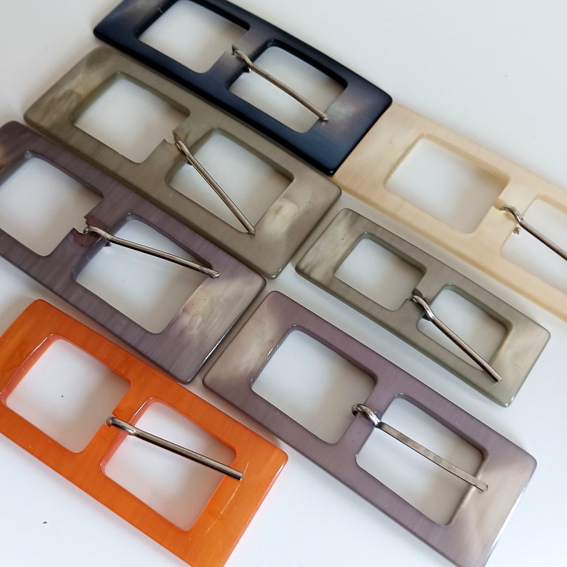the photo shows pearly plastic buckles rectangle shaped, in the 5 available colors
