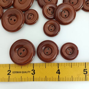 the buttons are photographed next to a tape measure
button size: 1.10 inches - 0.90 inches - 0.71 inches