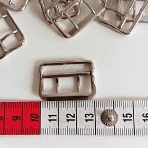 the photo shows the fastener  photographed next to a tape measure
size: cm 3 x 2