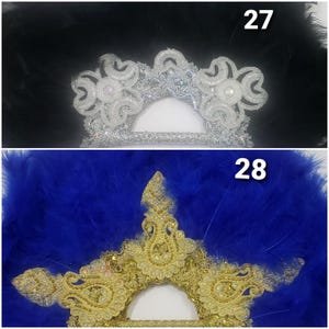 May include: Two decorative fans. The top fan has a silver and white beaded design with a black feather background. The bottom fan has a gold embroidered design with a blue feather background. The fans are numbered 27 and 28.