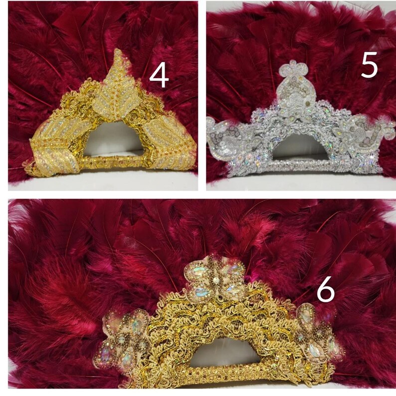 Puede incluir: Tres abanicos de plumas con diferentes adornos. El primer abanico tiene ribetes dorados y un dise&ntilde;o de corona dorada. El segundo abanico tiene ribetes plateados y un dise&ntilde;o de corona plateada. El tercer abanico tiene ribetes dorados y un dise&ntilde;o de corona dorada con una mariposa en el centro.