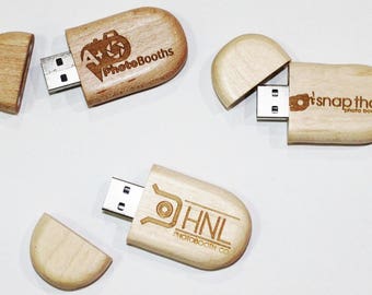 May include: Three wooden USB flash drives with different company logos engraved on them. The logos are "A+ PhotoBooths", "It's Snap That Photo Booths", and "HNL PhotoBooth Co."