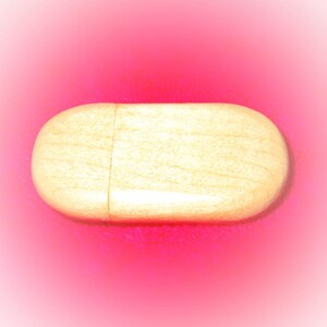 May include: A small, oval-shaped wooden box with a light brown finish. The box has a smooth surface and a subtle grain pattern.