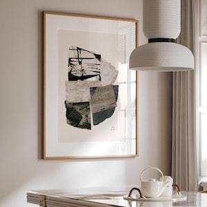 May include: A dining room scene featuring a rectangular table with a glass top and rattan chairs. A large framed abstract art piece hangs on the wall. A white pendant light hangs above the table. The room has a neutral color palette with natural light.