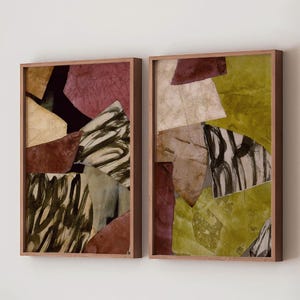 May include: A set of two rectangular wall art pieces in wooden frames, featuring abstract collage compositions of layered paper shapes in shades of olive green, deep burgundy, cream, and black, with visible brushstroke patterns and textures.