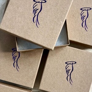May include: Multiple brown cardboard boxes with a blue angel wing design on the top of each box.