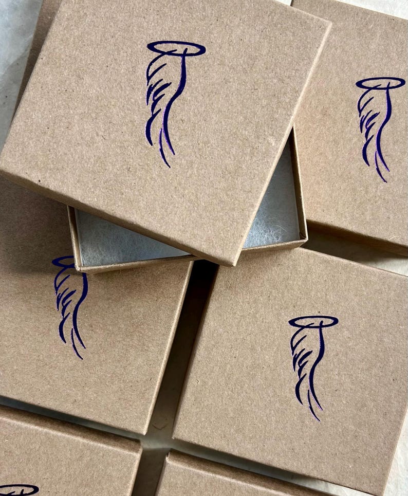 May include: Multiple brown cardboard boxes with a blue angel wing design on the top of each box.