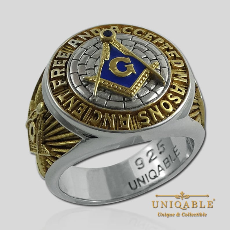 Pu&ograve; includere: Un anello massonico in argento e oro con un designo a squadra e compasso blu e oro. L'anello &egrave; inciso con "Free and Accepted Masons" e "925 Uniqable".