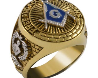 Può includere: Un anello massonico in oro con un designo a quadrato e compasso blu e bianco. L'anello ha le parole "Free and Accepted Masons" incise attorno al design.