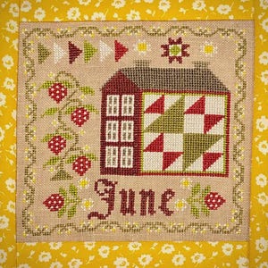 May include: A cross-stitch design featuring a house with a red roof and a star-shaped embellishment. The house has a patchwork design in red, green, and white. The word "June" is stitched below the house, and strawberry vines frame the design. The background is a yellow floral pattern.