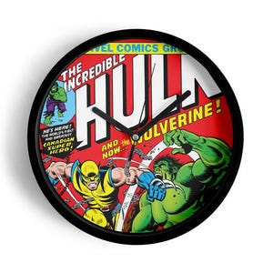 May include: Round black wall clock featuring a comic book cover design with the Incredible Hulk and Wolverine. The clock face is red with white text and illustrations of the characters. The clock has black hands.