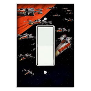 May include: A light switch cover featuring a black and red space scene with multiple X-Wing starfighters flying in formation. The scene is set against a backdrop of stars and a red planet.