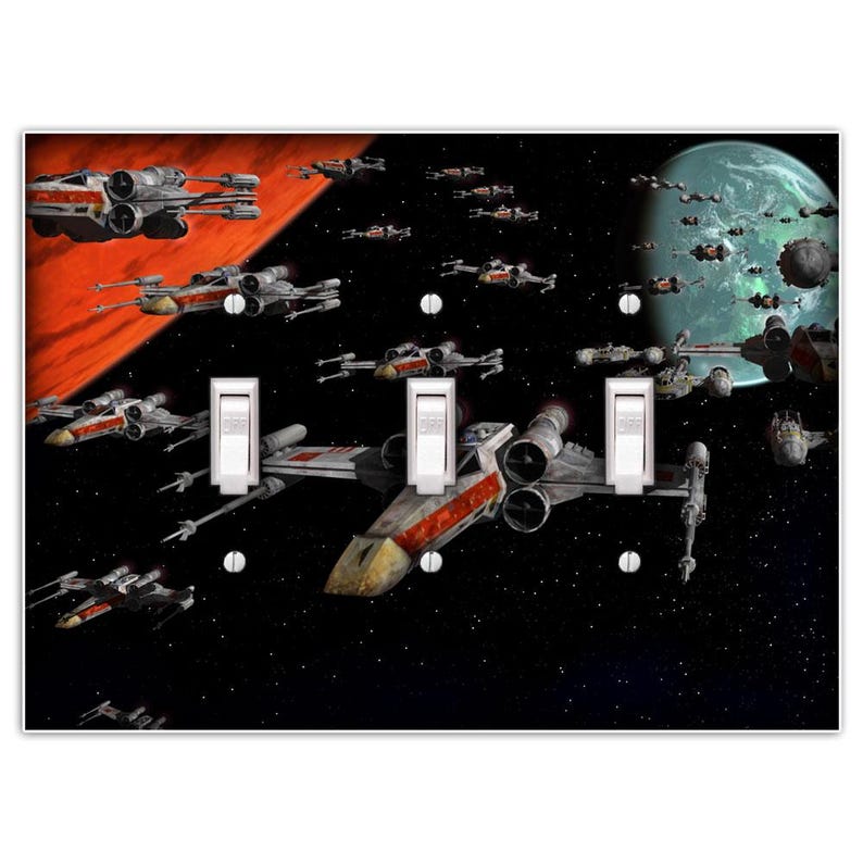 May include: A light switch plate featuring a Star Wars themed design with X-Wing fighters flying through space. The background is a dark blue with stars and a red planet. The switch plate has three toggle switches.