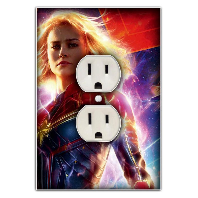 May include: A light switch cover featuring a colourful image of Captain Marvel, a superhero from the Marvel Cinematic Universe. The image shows Captain Marvel in a blue and red costume, with a glowing energy effect behind her. The switch cover is designed to fit a standard UK outlet.