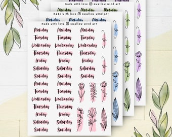 Pode incluir: Um conjunto de adesivos de planejador imprimíveis com os dias da semana, designs florais e bordas desenhadas à mão. Os adesivos estão em lavagens de aquarela rosa, azul e verde.