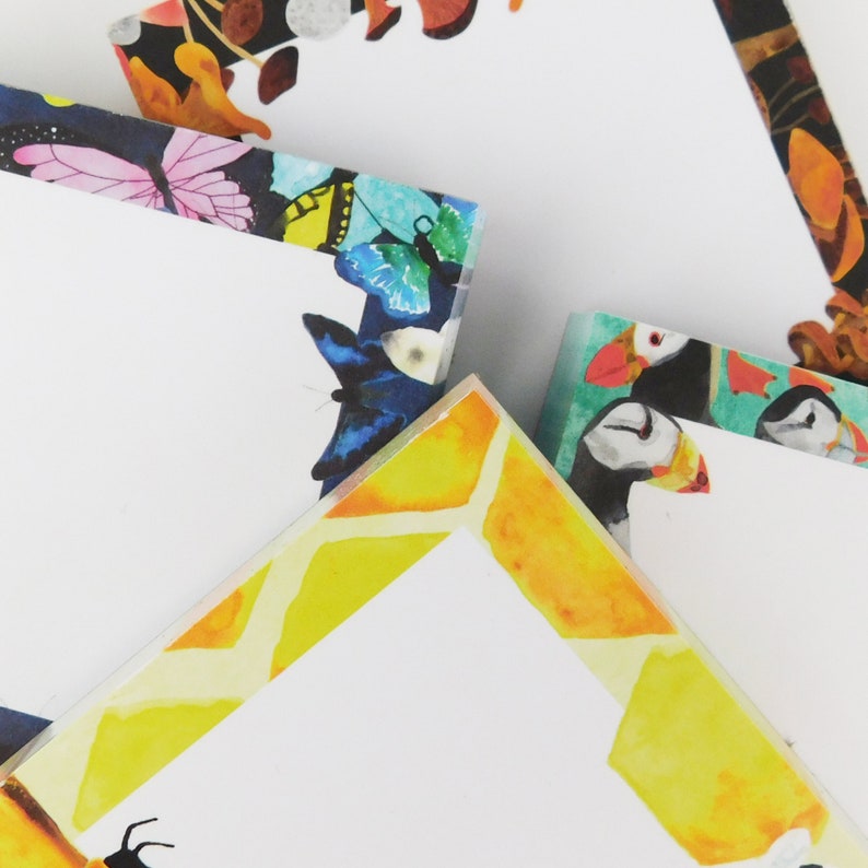 May include: A set of four colorful notepad sets with different designs. The designs include butterflies, a honeycomb pattern, and puffins. The notepads are perfect for taking notes, writing lists, or leaving messages.