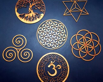 May include: Six wooden wall decor pieces with various spiritual and geometric designs. The designs include a tree of life, a flower of life, a triple spiral, a seed of life, a star of David, and an Om symbol.