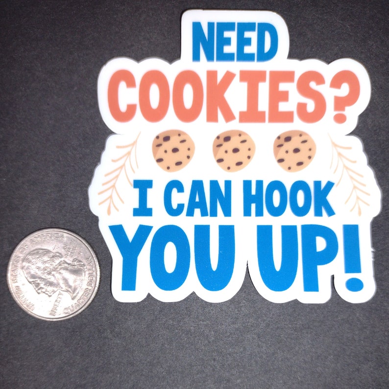 May include: White sticker with blue and orange text that reads "Need Cookies? I can hook you up!" with three brown chocolate chip cookies in the middle.