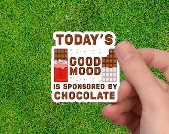 May include: A sticker with a brown and white chocolate bar design. The text reads "Today's Good Mood is Sponsored by Chocolate."