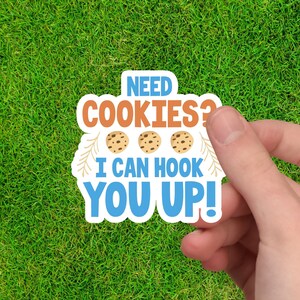 May include: A blue and orange sticker with the text "NEED COOKIES? I CAN HOOK YOU UP!" and three cartoon cookies.