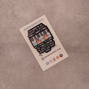 May include: A colorful enamel pin featuring a piano with hands playing. The pin has a quote that reads: "God grant me the serenity to accept things I cannot change, the courage to change the things I can and the wisdom to know when to just play piano."