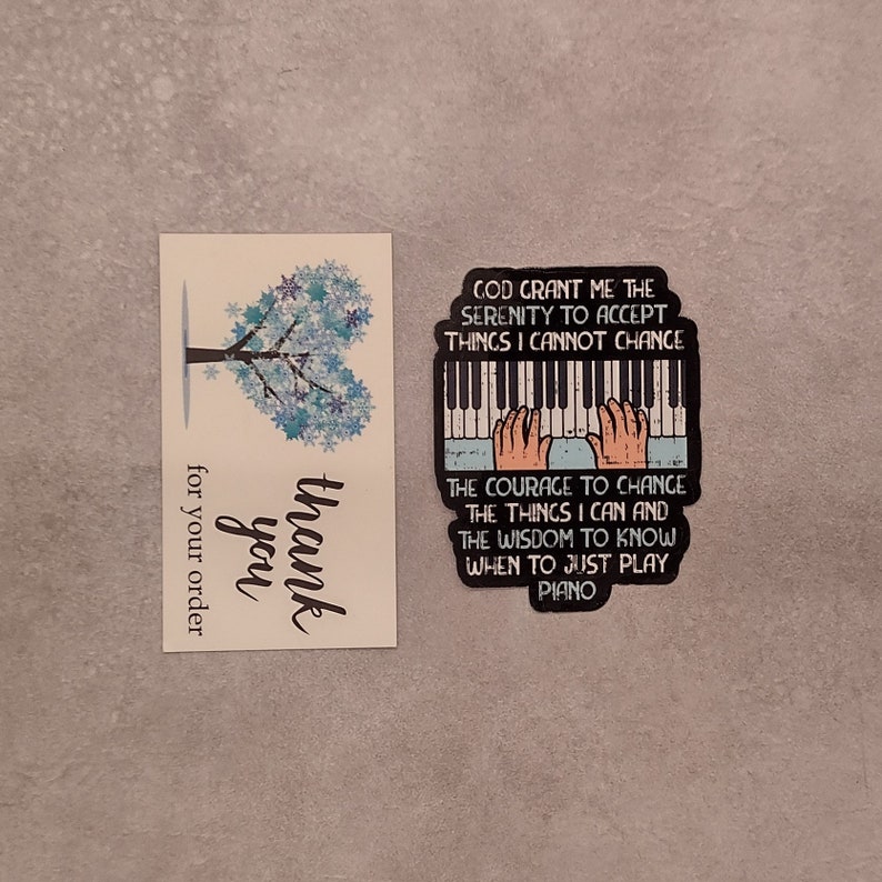 May include: A thank you card with a blue snowflake tree design and the text "thank you for your order". A sticker with a piano keyboard and hands playing with the text "God grant me the serenity to accept things I cannot change. The courage to change the things I can and the wisdom to know when to just play piano."