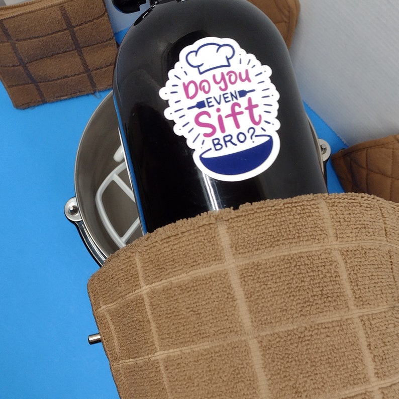 May include: A black stand mixer with a white bowl and a sticker that says "Do you even sift bro?" on the side.