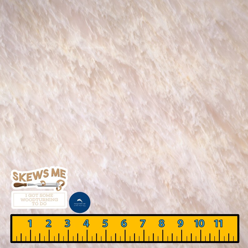 May include: A close-up of a light beige wood grain surface with a ruler and a sticker that says "Skews Me I got some woodturning to do".