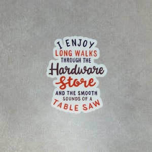 May include: White sticker with the text "I enjoy long walks through the hardware store and the smooth sounds of a table saw". The text is in black and red.