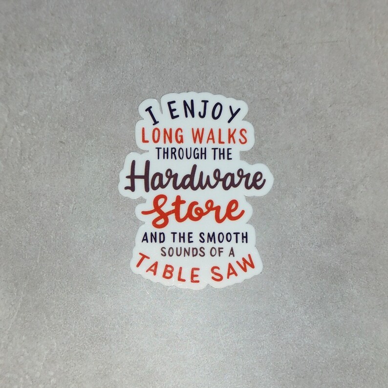May include: White sticker with the text "I enjoy long walks through the hardware store and the smooth sounds of a table saw". The text is in black and red.