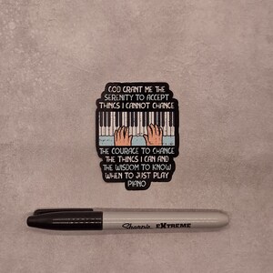 May include: A sticker with a piano keyboard and the text "God grant me the serenity to accept things I cannot change. The courage to change the things I can and the wisdom to know when to just play piano."