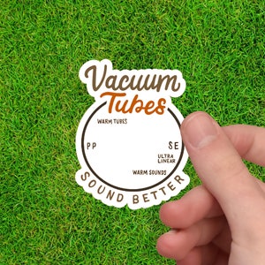 May include: A white sticker with brown text that reads "Vacuum Tubes Sound Better". The sticker has a circle in the middle with the text "Warm Tubes" and "Warm Sounds" inside the circle. The circle also has the text "PP" and "SE" on either side of the circle.