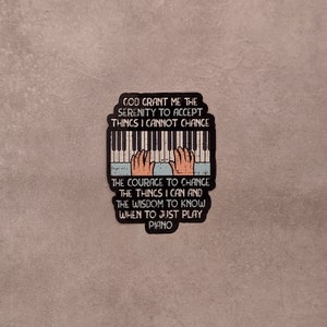 May include: A black and white sticker with a piano keyboard and hands playing. The text reads "God grant me the serenity to accept things I cannot change. The courage to change the things I can and the wisdom to know when to just play piano."