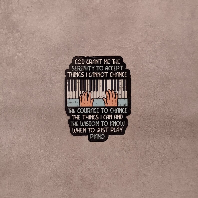 May include: A black and white sticker with a piano keyboard and hands playing. The text reads "God grant me the serenity to accept things I cannot change. The courage to change the things I can and the wisdom to know when to just play piano."