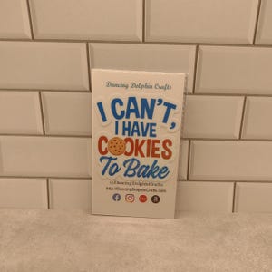 Może przedstawiać: Biała naklejka z niebieskim i czerwonym tekstem, kt&oacute;ry brzmi "I CAN'T, I HAVE COOKIES To Bake". Naklejka przedstawia brązowe ciasteczko z czekoladowymi kawałkami.