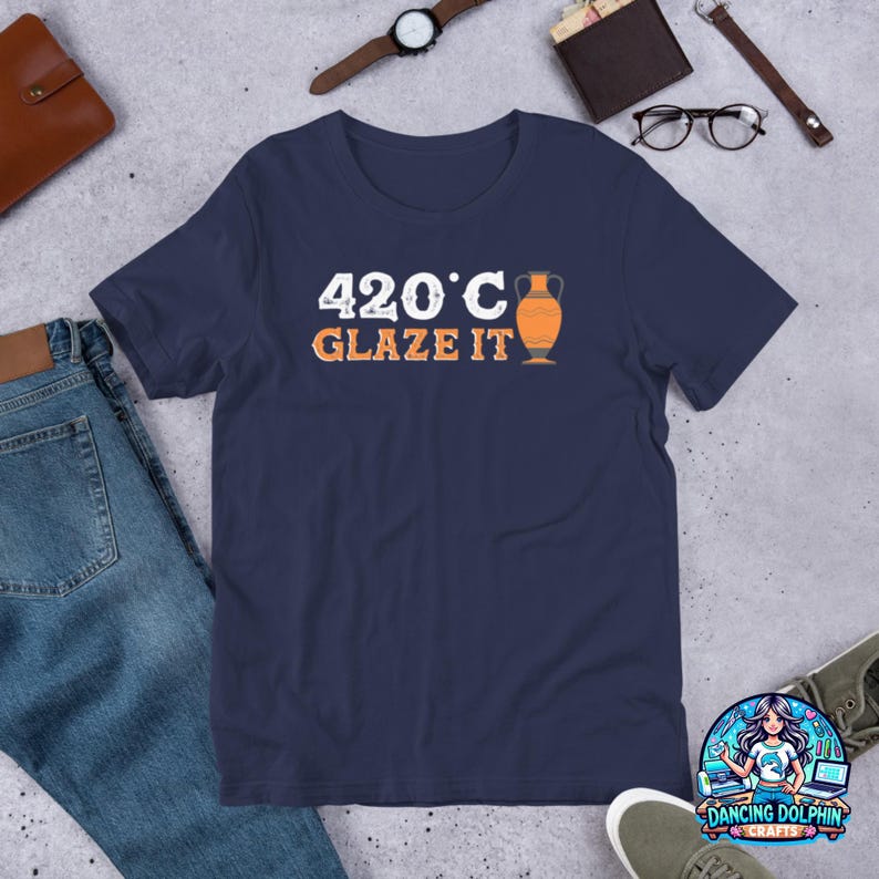 May include: Navy blue t-shirt with white text that reads "420&deg;C Glaze It" and a graphic of an orange clay pot.