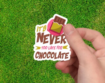 May include: A white sticker with pink and brown text that reads "It's Never Too Late For Chocolate". A cartoon chocolate bar is in the upper left corner of the sticker.