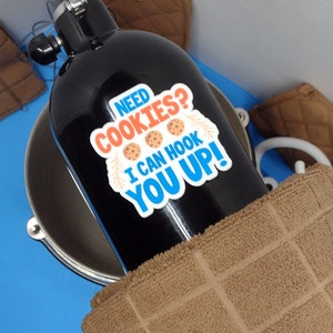 May include: A black scuba diving tank with a blue and orange sticker that says "Need Cookies? I can hook you up!" with three cookie images.