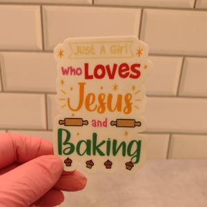 May include: White sticker with the text "Just a Girl who Loves Jesus and Baking" in colorful letters. The sticker features a rolling pin, stars, and cupcakes.