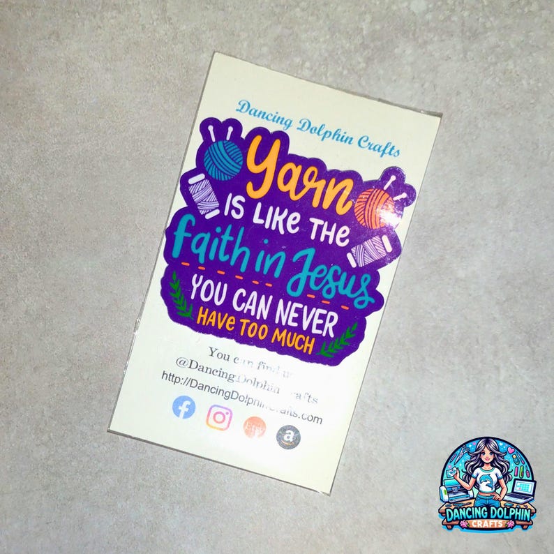 May include: A white rectangular card with the text "Yarn is like the faith in Jesus, you can never have too much." The card also includes the Dancing Dolphin Crafts logo and social media handles.